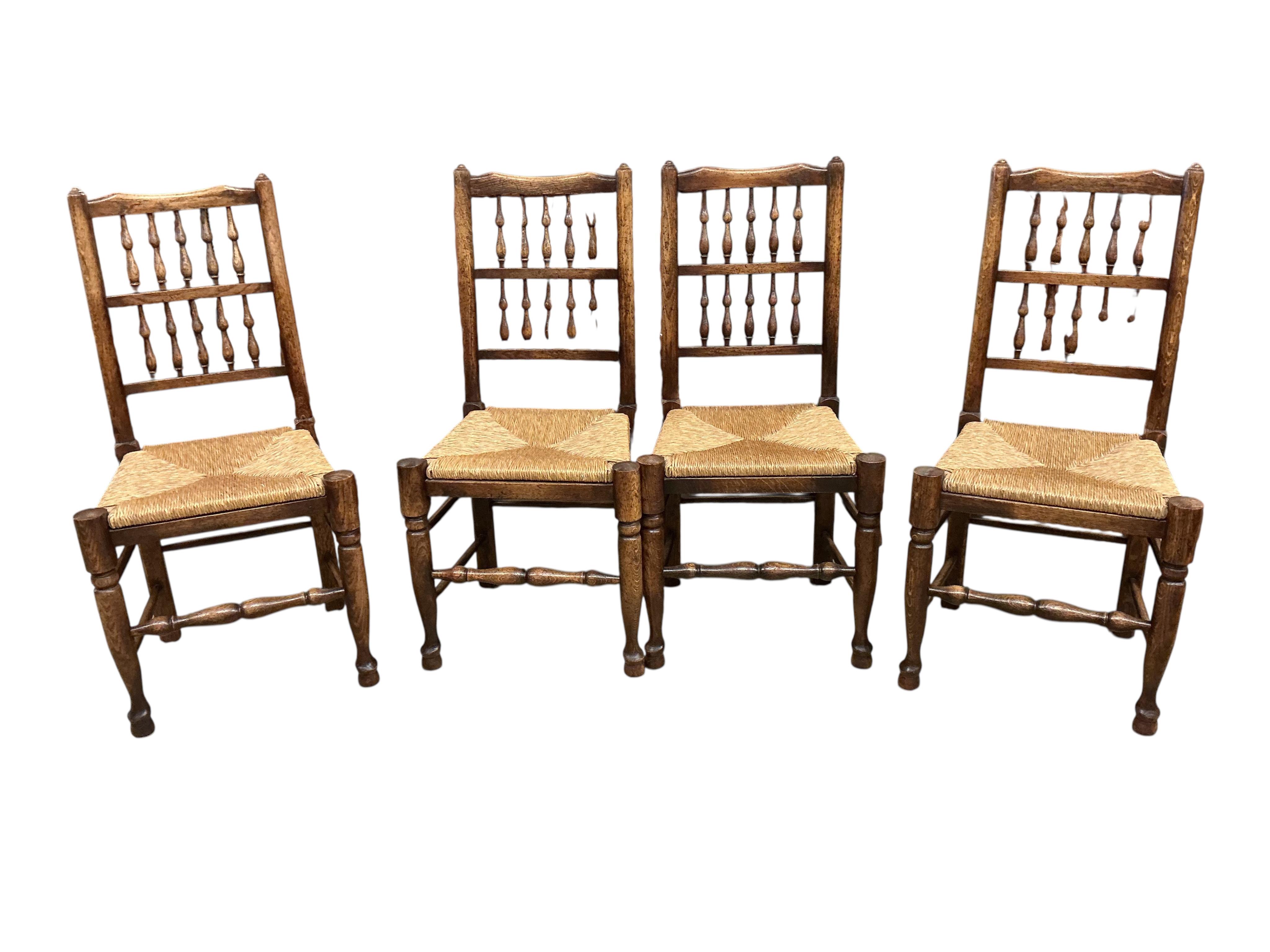 A set of ten Lancashire style ash and beech rush seat spindle back dining chairs, two with arms
